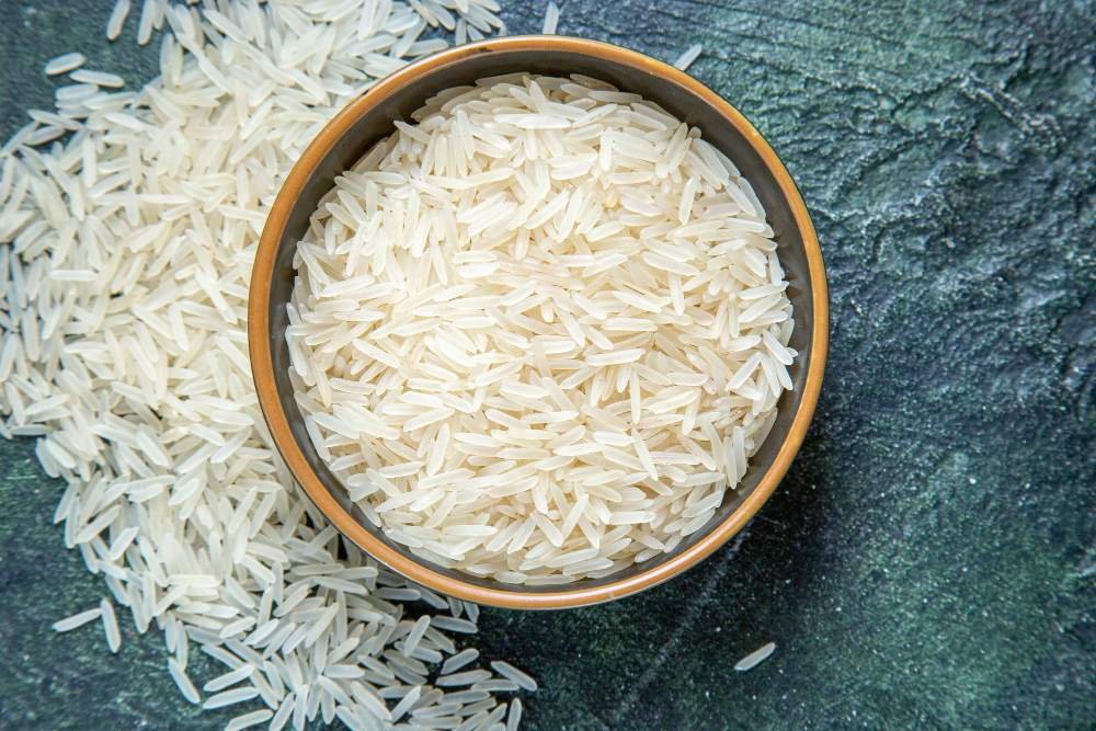 vista-superior-arroz-crudo-dentro-placa-escritorio-oscuro-mdjaff